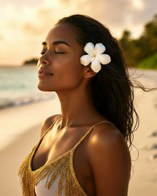 Woman with a white flower in her hair on a beach at sunset